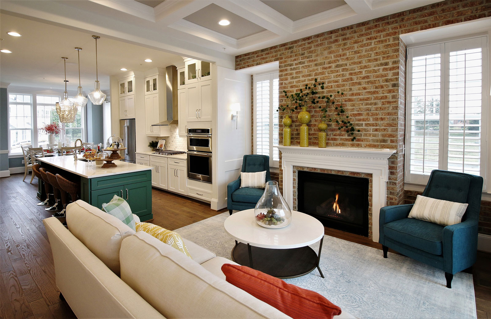 Open floor plan model home in Maryland merchandised with an accent brick wall, fireplace, and classic kitchen.