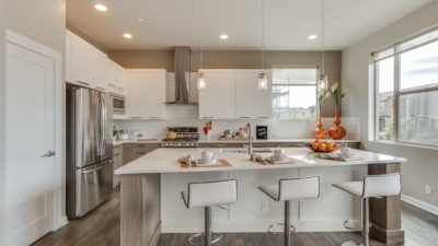 Modern model townhome white kitchen with moden cabinets and hardwood floors