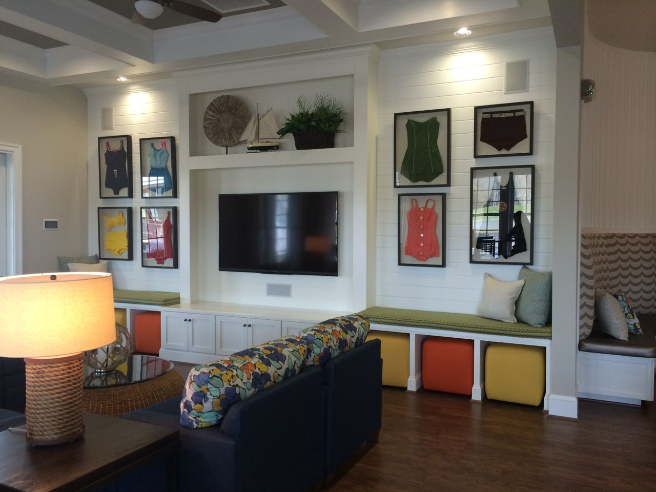 Multifamily clubhouse interior designed with framed vintage swimsuits and bright colors.