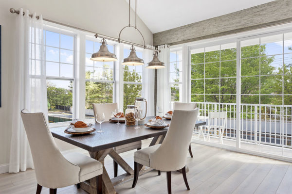 Cream dining room surrounded by windows bringing the indoor to outdoors