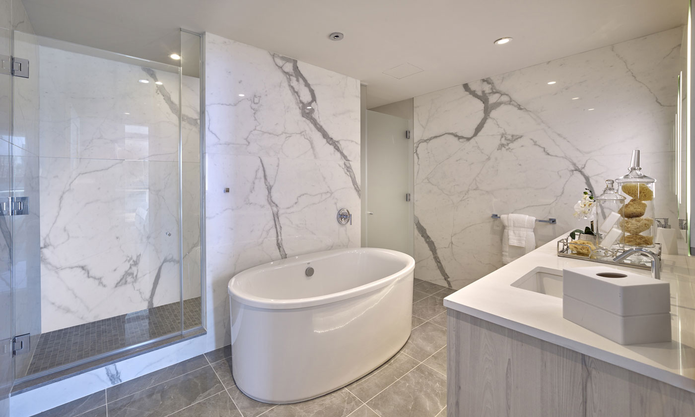 Apartment master bathroom with full white marble walls, oversized shower and upscale finishes in New Jersey.