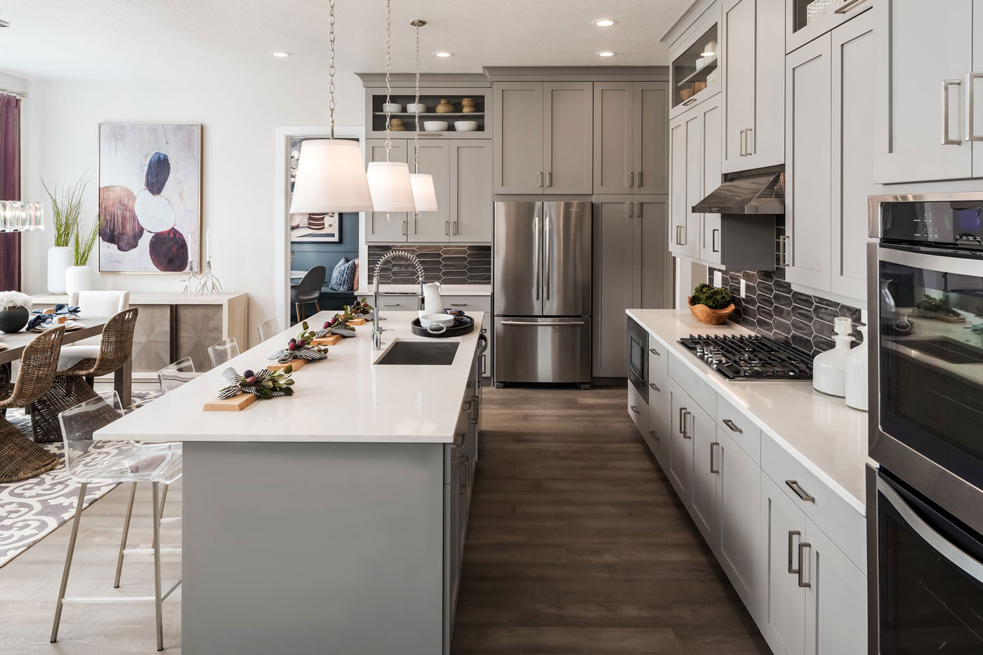 Light gray cabinetry, quartz countertops, and contrasting gray tile backsplash in Utah kitchen.