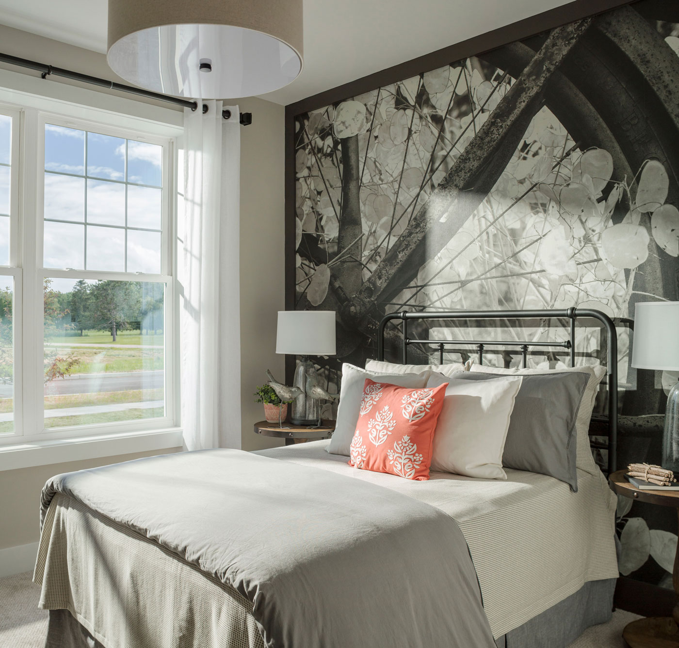 Full wall mural brings outside in and soft gray finishes help create a relaxing bedroom in Vermont model home.