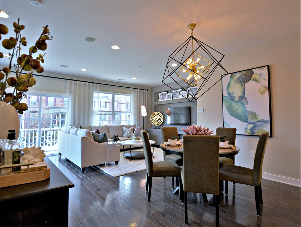 Townhome living and dining area designed with neutral finishes and a large black geometric chandelier, in Pennsylvania.